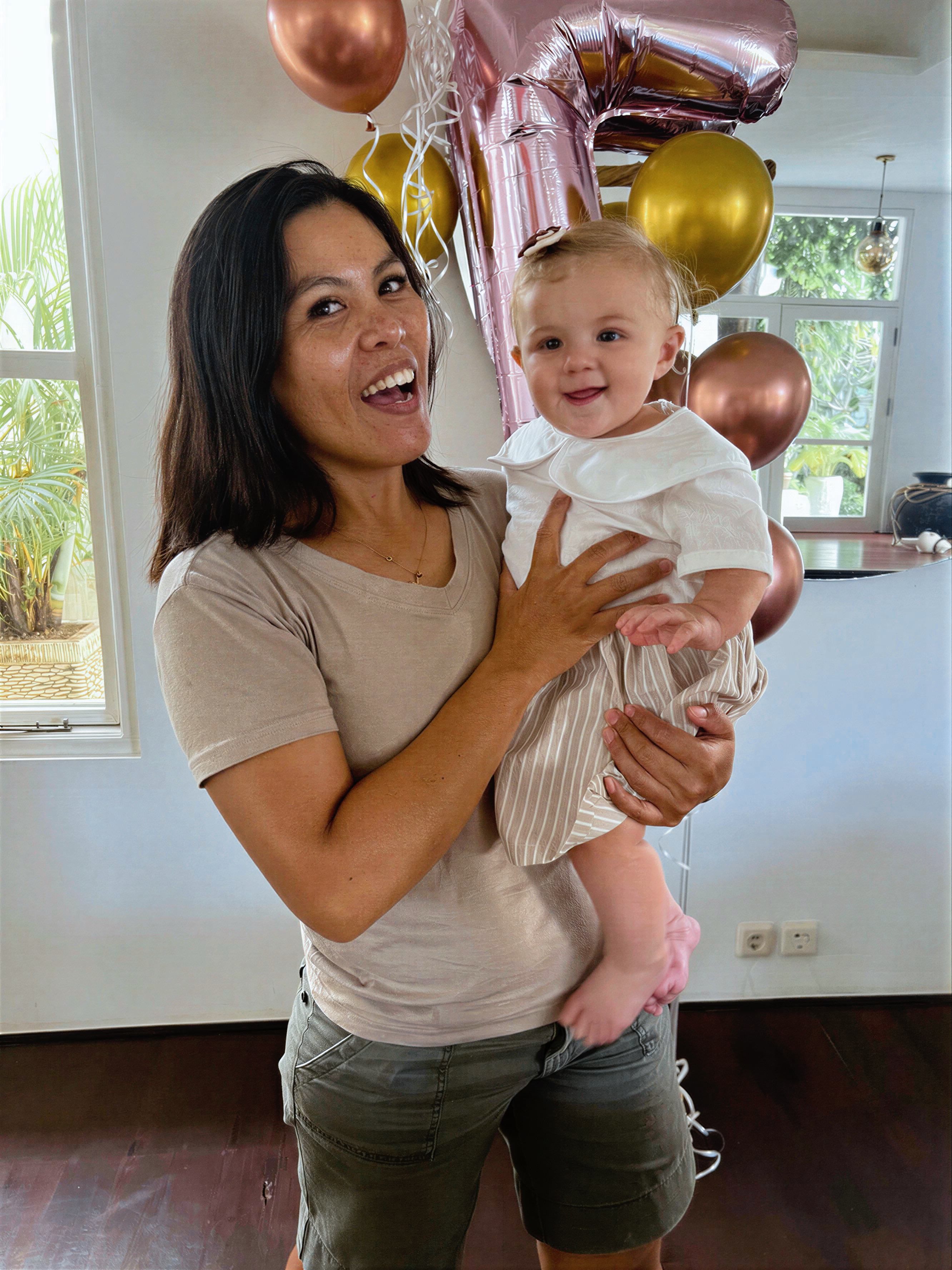 Vera, founder of Joyful Nanny Bali, holding a happy baby